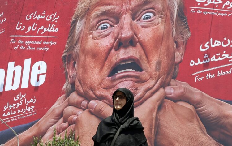 Mujer camina delante de un mensaje anti-Trump en Tehran. Foto: ABEDIN TAHERKENAREH/EFE/EPA.