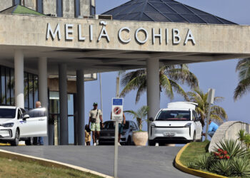 Personas caminan frente a un hotel de la cadena hotelera española Meliá este martes, en La Habana. Foto: Ernesto Mastrascusa/EFE.