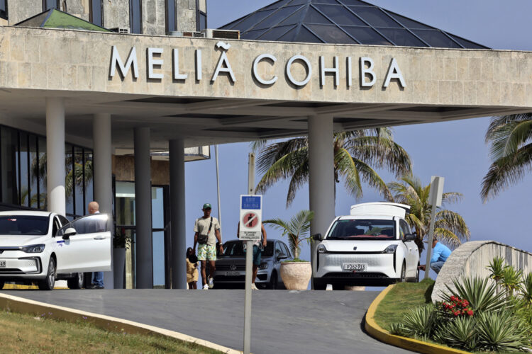 Personas caminan frente a un hotel de la cadena hotelera española Meliá este martes, en La Habana. Foto: Ernesto Mastrascusa/EFE.