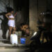 Dos mujeres llenan recipientes con agua durante un apagón en La Habana. Foto: Ernesto Mastrascusa / EFE.