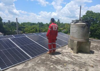 Un voluntario de la Cruz Roja junto a paneles solares instalados por esa entidad en un centro de salud de la provincia de Granma. Foto: Radio Ciudad Monumento / Facebook.
