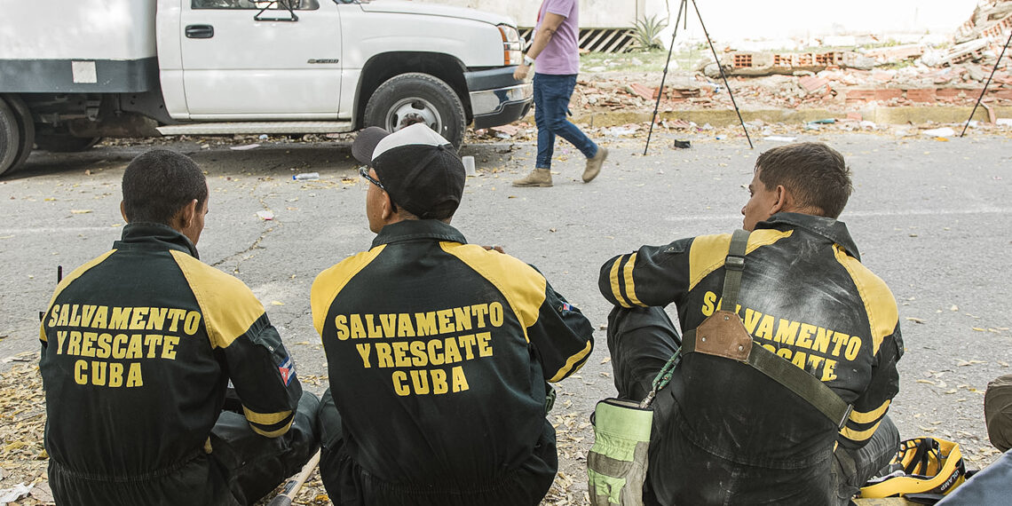Integrantes del equipo de Salvamento y Rescate de Cuba reposan durante un operativo para salvar a un niño de nueve años tras ocho días entre los escombros de una edificación derrumbada por el doble terremoto en Venezuela. Foto: Henry Chirinos / EFE.