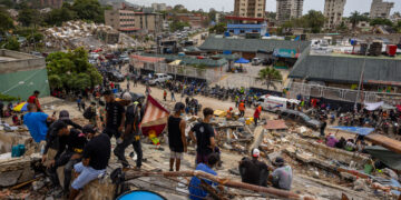 Personas observan edificios colapsados por los terremotos este martes, en La Guaira (Venezuela). Foto: Miguel Gutiérrez/EFE.