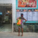 Una mujer lee la pizarra de precios de un negocio privado en La Habana. Foto: Otmaro Rodríguez.