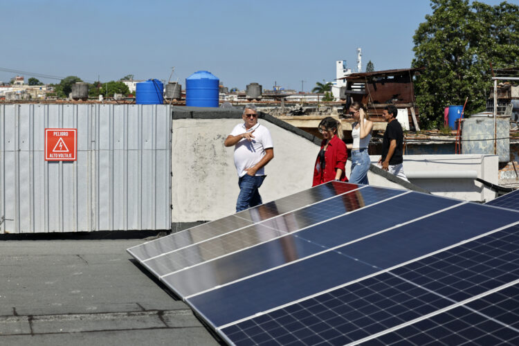 Presidente de JOLYNI S.U.R.L, Jorge Félix Peraza Noriega, caminando junto a paneles fotovoltaicos en La Habana. Foto:  Ernesto Mastrascusa/EFE.