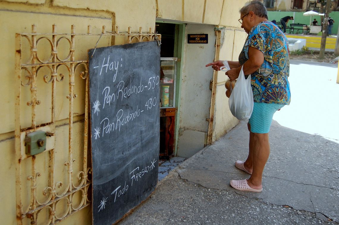 Una mujer observa la pizarra de precios en una bodeguita privada en La Habana, en agosto de 2026. Foto: AMD.