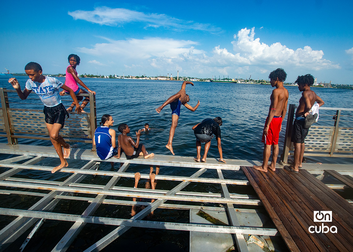 Niños y jóvenes en el muelle flotante, frente a la Alameda de Paula, en La Habana. Foto: Otmaro Rodríguez.
