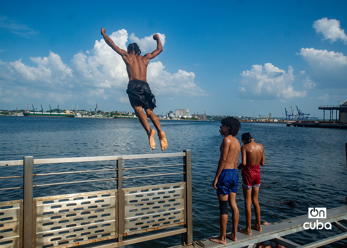 Niños y jóvenes en el muelle flotante, frente a la Alameda de Paula, en La Habana. Foto: Otmaro Rodríguez.