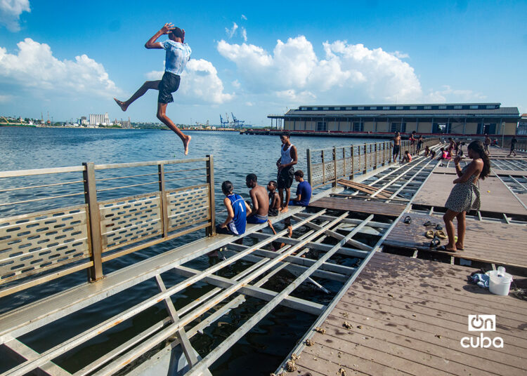 Niños y jóvenes en el muelle flotante, frente a la Alameda de Paula, en La Habana. Foto: Otmaro Rodríguez.