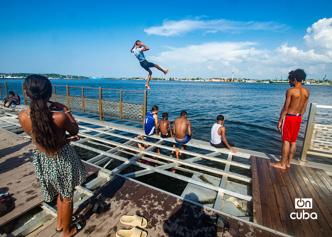 Niños y jóvenes en el muelle flotante, frente a la Alameda de Paula, en La Habana. Foto: Otmaro Rodríguez.