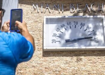 Una persona registra el momento histórico del récord de temperatura en Miami. Foto: EFE.