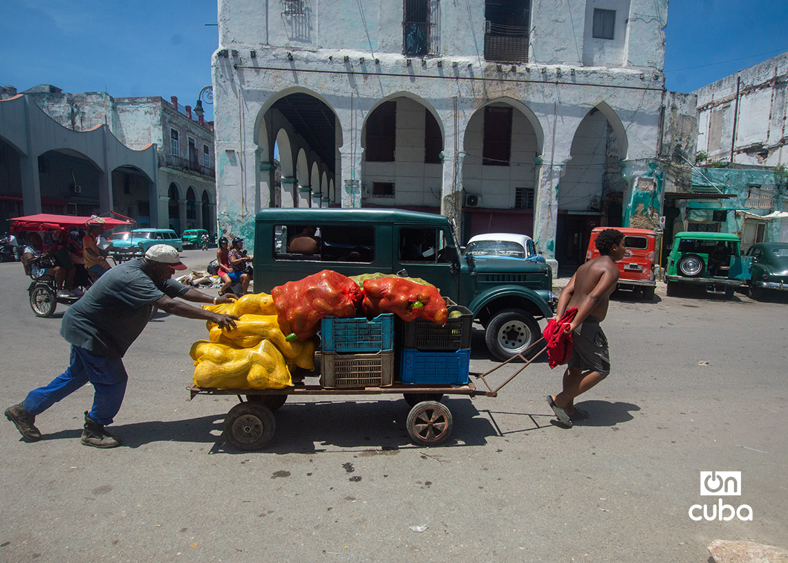 Un hombre y su hijo empujan una carretilla de mercancías en La Habana, en el contexto del centenario de Fidel Castro. Foto: Otmaro Rodríguez.