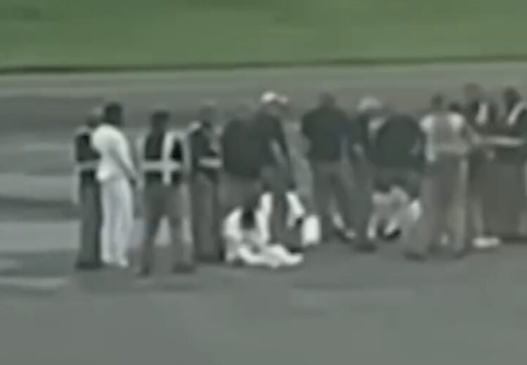 Captura de un video donde se aprecia a los cinco deportados sentados en la losa del aeropuerto, en Liberia, escoltados por personal de seguridad.