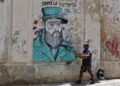 Una persona camina este jueves, junto a un grafiti de Fidel Castro, en La Habana. Foto: Ernesto Mastrascusa/EFE.