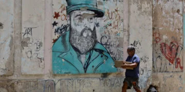 Una persona camina este jueves, junto a un grafiti de Fidel Castro, en La Habana. Foto: Ernesto Mastrascusa/EFE.