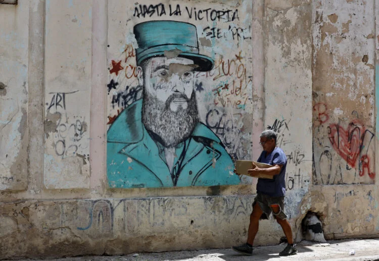 Una persona camina este jueves, junto a un grafiti de Fidel Castro, en La Habana. Foto: Ernesto Mastrascusa/EFE.