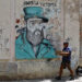 Una persona camina este jueves, junto a un grafiti de Fidel Castro, en La Habana. Foto: Ernesto Mastrascusa/EFE.