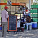 Un hombre mira la pizarra de precios de un puesto de comida en una calle en La Habana. Foto: Ernesto Mastrascusa / EFE.