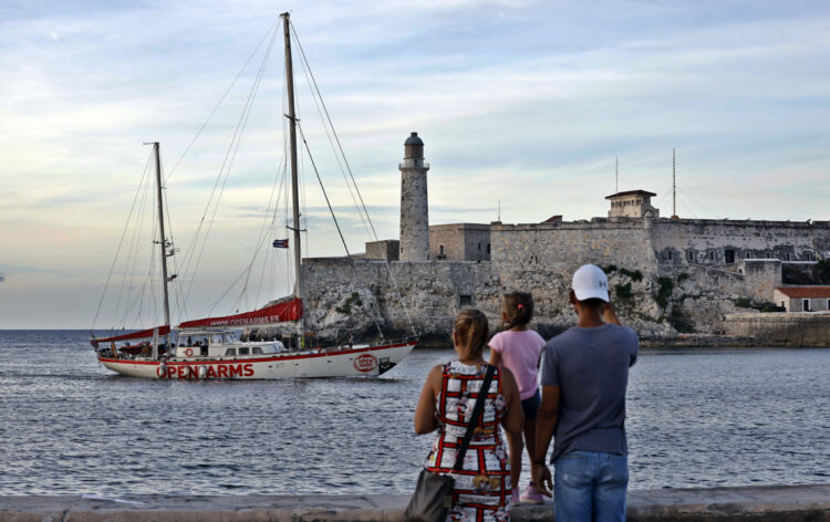 Personas observan la entrada en La Habana del velero Astral de Open Arms cargado con siete toneladas de ayuda humanitaria para Cuba, el 30 de agosto de 2026. Foto: Ernesto Mastrascusa / EFE.