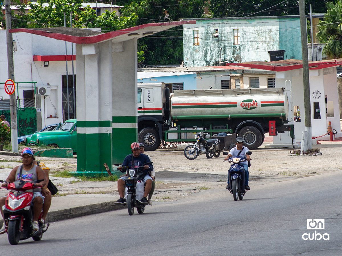Motos eléctricas circulan cerca de un camión de combustible en La Habana. Foto: Otmaro Rodríguez.