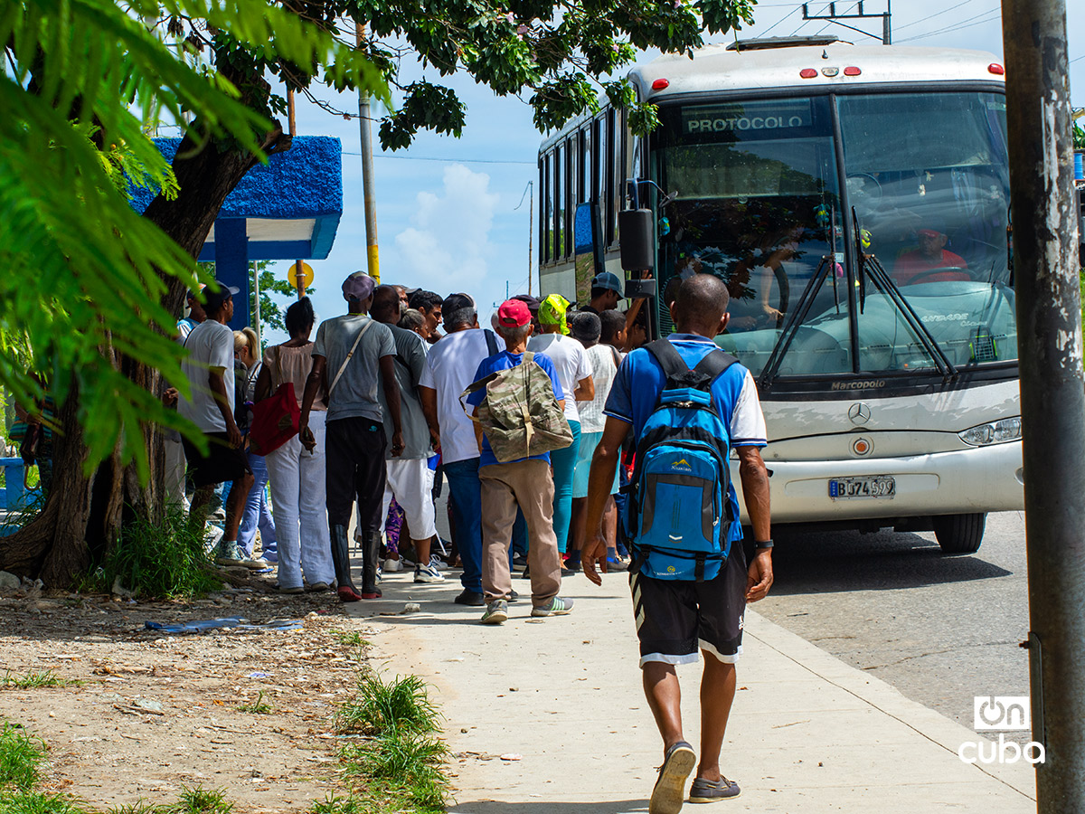 Personas hacen cola para subir a un ómnibus en La Habana. Foto: Otmaro Rodríguez.