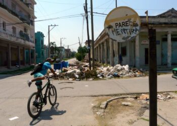 Graffiti en una señal de tránsito, cerca de una acumulación de basura en La Habana. Foto: AMD.