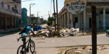 Graffiti en una señal de tránsito, cerca de una acumulación de basura en La Habana. Foto: AMD.