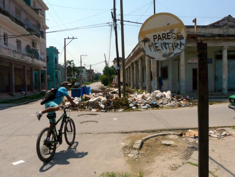 Graffiti en una señal de tránsito, cerca de una acumulación de basura en La Habana. Foto: AMD.