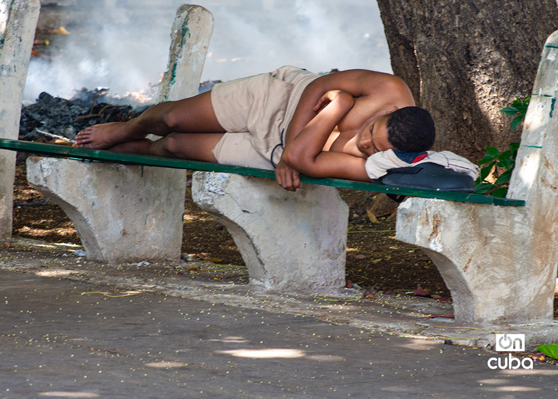 Persona durmiendo en un banco del Parque de los Enamorados, en La Habana. Foto: Otmaro Rodríguez.