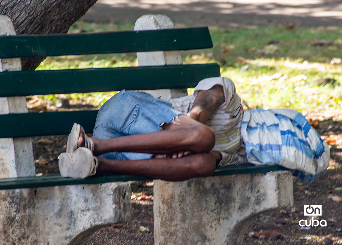 Persona durmiendo en un banco del Parque de los Enamorados, en La Habana. Foto: Otmaro Rodríguez.