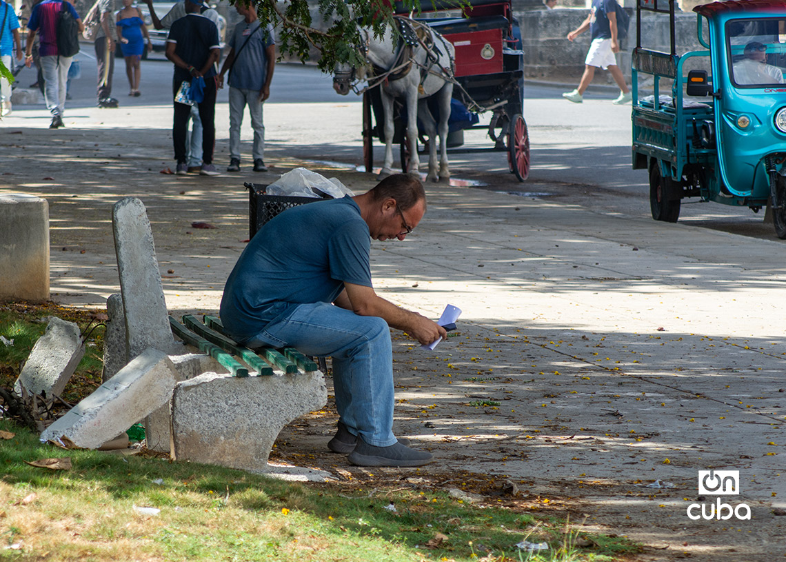 Un hombre descansa en un banco en mal estado, en el Parque de los Enamorados, en La Habana. Foto: Otmaro Rodríguez.