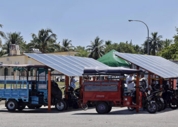 Personas cargan sus motos eléctricas en una 'solinera' el 31 de agosto de 2026 en La Habana (Cuba). Foto: Ernesto Mastrascusa/EFE.