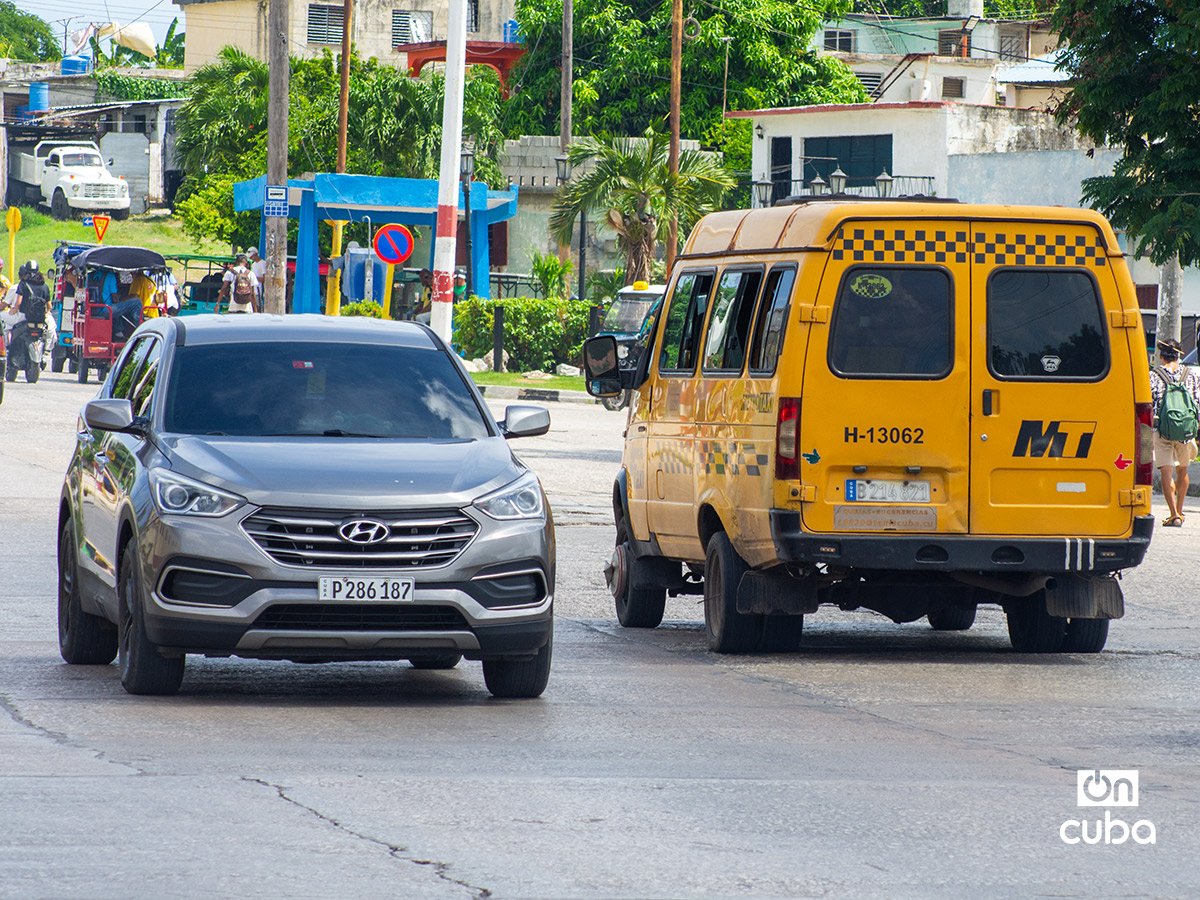 Un taxi rutero junto a un auto en La Habana. Foto: Otmaro Rodríguez.
