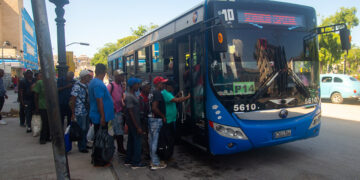 Personas hacen cola para subir a un ómnibus en La Habana. Foto: Otmaro Rodríguez.
