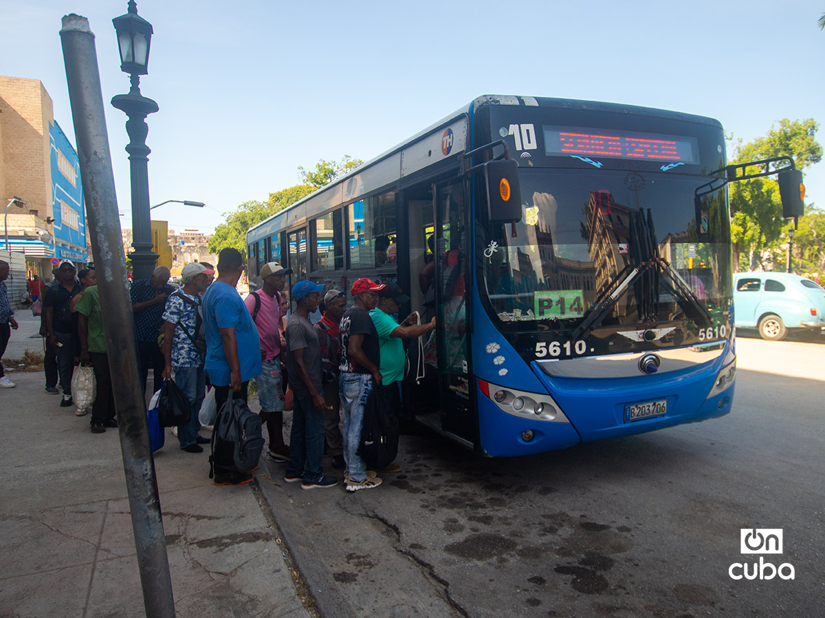 Personas hacen cola para subir a un ómnibus en La Habana. Foto: Otmaro Rodríguez.