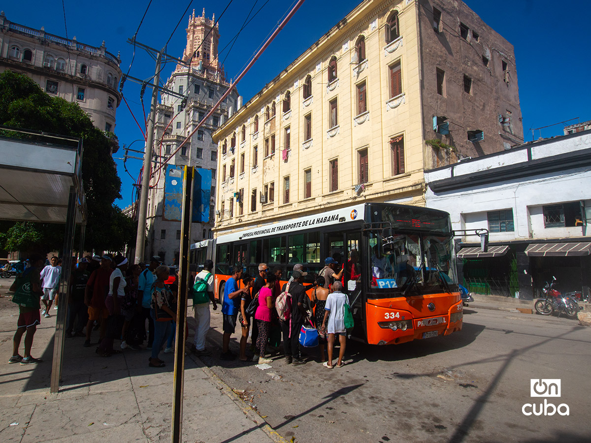 Personas hacen cola para subir a un ómnibus en La Habana. Foto: Otmaro Rodríguez.