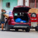 Dos hombres echan gasolina en un auto, junto a un punto de venta informal, en La Habana. Foto: Otmaro Rodríguez.