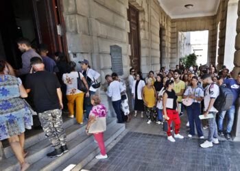 Cubanos esperan frente al Consulado de España este martes, en La Habana mientras el Tribunal Supremo (TS) español ha dejado en suspenso las altas incorporadas al Censo Electoral de Residentes Ausentes (CERA) como consecuencia de la Ley de Memoria Democrática. Foto: EFE/ Ernesto Mastrascusa.