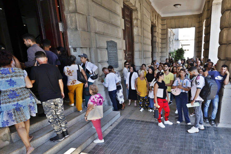 Cubanos esperan frente al Consulado de España este martes, en La Habana mientras el Tribunal Supremo (TS) español ha dejado en suspenso las altas incorporadas al Censo Electoral de Residentes Ausentes (CERA) como consecuencia de la Ley de Memoria Democrática. Foto: EFE/ Ernesto Mastrascusa.