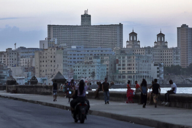 Personas transitan el malecón durante un apagón. Foto: Ernesto Mastrascusa/EFE.