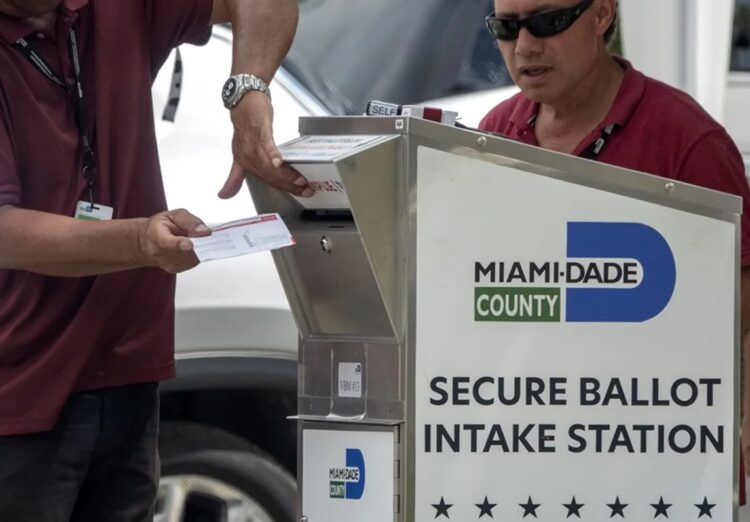 Funcionarios electorales ayudando a los votantes a depositar su boleta de voto por correo en un buzón oficial. Foto: Cristobal Herrera-Ulashkevich/EFE/Epa.