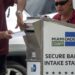 Funcionarios electorales ayudando a los votantes a depositar su boleta de voto por correo en un buzón oficial. Foto: Cristobal Herrera-Ulashkevich/EFE/Epa.