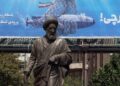 Una estatua se alza frente a una valla publicitaria que muestra un dron submarino estadounidense capturado por el ejército iraní y una frase en persa que dice "Cazando al cazador", en Teherán, Irán, el 9 de septiembre de 2026. Foto: ABEDIN TAHERKENAREH/EFE/EPA.