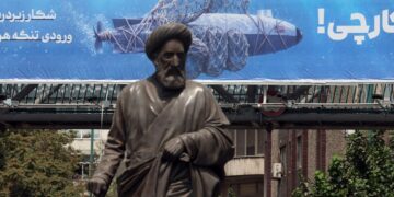 Una estatua se alza frente a una valla publicitaria que muestra un dron submarino estadounidense capturado por el ejército iraní y una frase en persa que dice "Cazando al cazador", en Teherán, Irán, el 9 de septiembre de 2026. Foto: ABEDIN TAHERKENAREH/EFE/EPA.