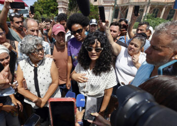 La creadora de contenido cubana, Anna Sofía Benítez, conocida en redes sociales como Anna Bensi (c), habla con periodistas al salir del Tribunal Municipal este jueves, en La Habana. Foto: EFE/Ernesto Mastrascusa.