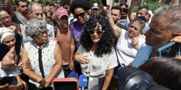 La creadora de contenido cubana, Anna Sofía Benítez, conocida en redes sociales como Anna Bensi (c), habla con periodistas al salir del Tribunal Municipal este jueves, en La Habana. Foto: EFE/Ernesto Mastrascusa.