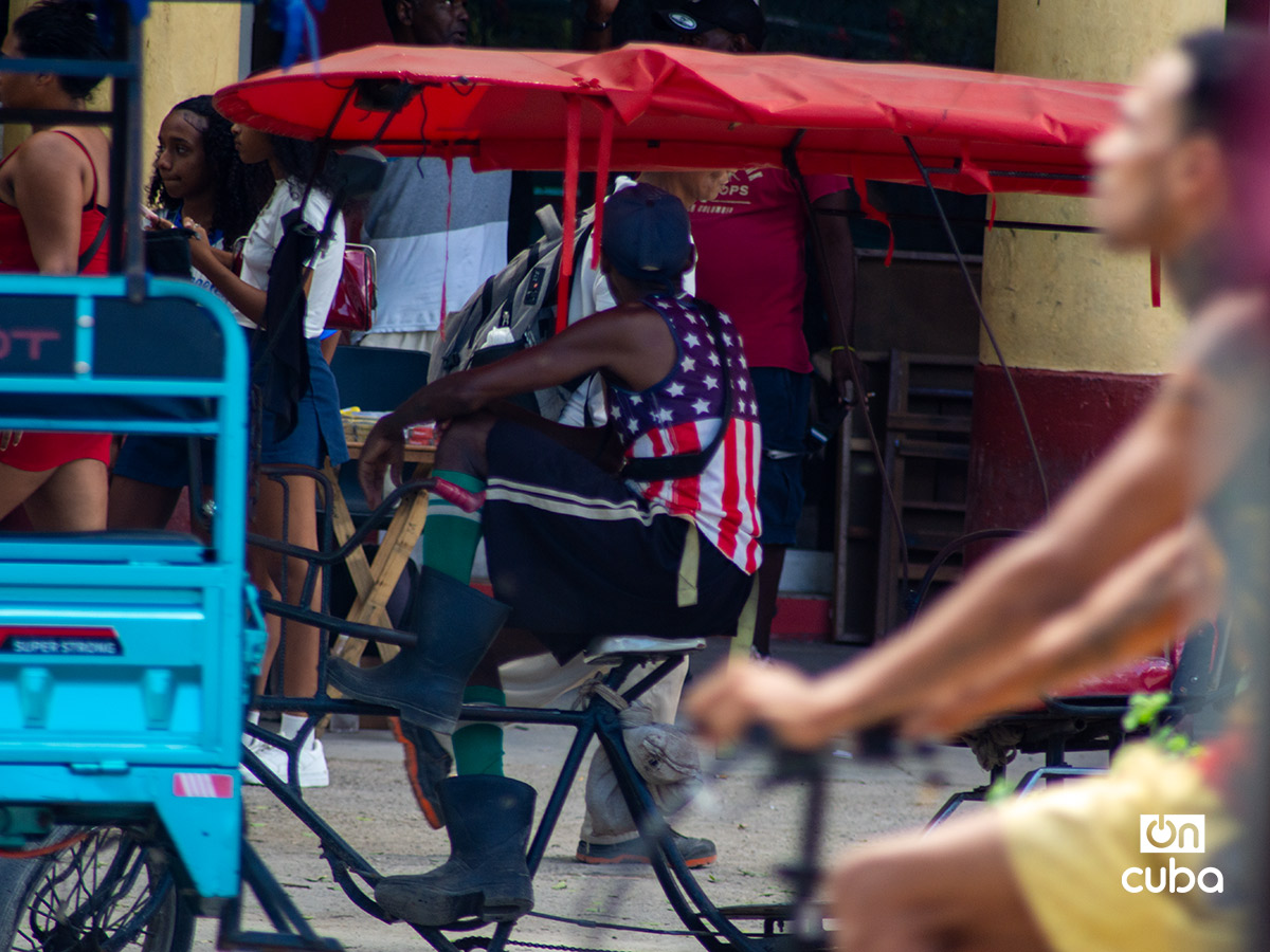 Chofer de bicitaxi con una camiseta con la bandera de Estados Unidos, en La Habana. Foto: Otmaro Rodríguez.