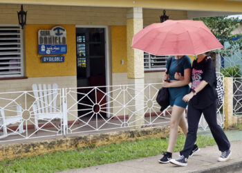 Fotografía de septiembre de 2026 que muestra dos personas caminando frente a una casa de renta a turistas con un cartel de disponibilidad, en pueblo Viñales, en Pinar del Río. Foto: Ernesto Mastrascusa / EFE / Archivo.