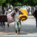Un hombre carga bultos en el Paseo del Prado, en La Habana. Foto: Otmaro Rodríguez.