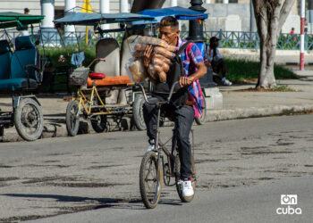 Un hombre carga bolsos de pan en una bicicleta en La Habana. Foto: Otmaro Rodríguez.